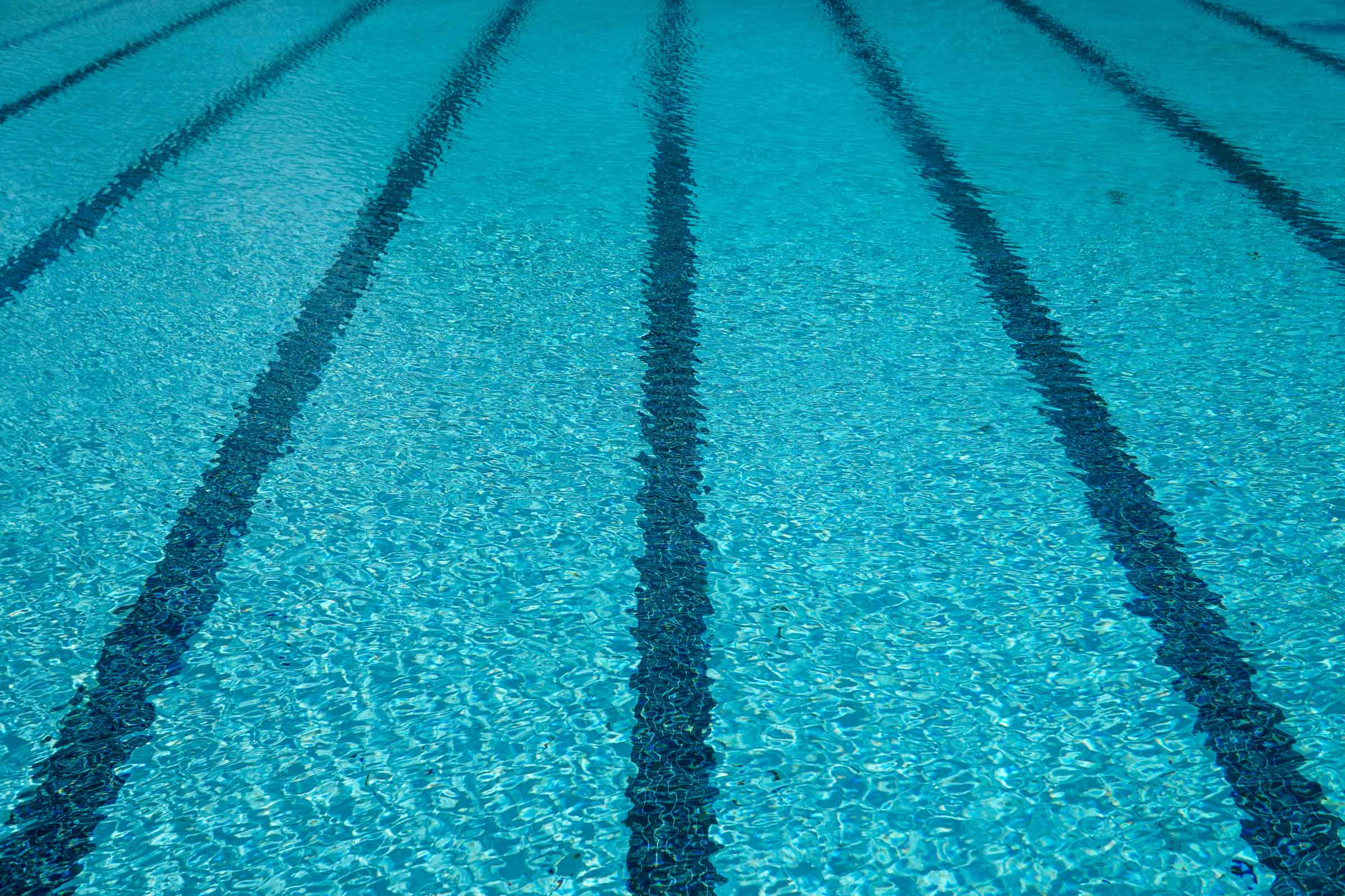 Celestial-Solar-Pool-header-Banner-Image-2400×1600-1 Celestial Solar banner image featuring a turquoise pool with bold dark blue lane lines, sunlit ripples, and shimmering water texture for an energized outdoor atmosphere.