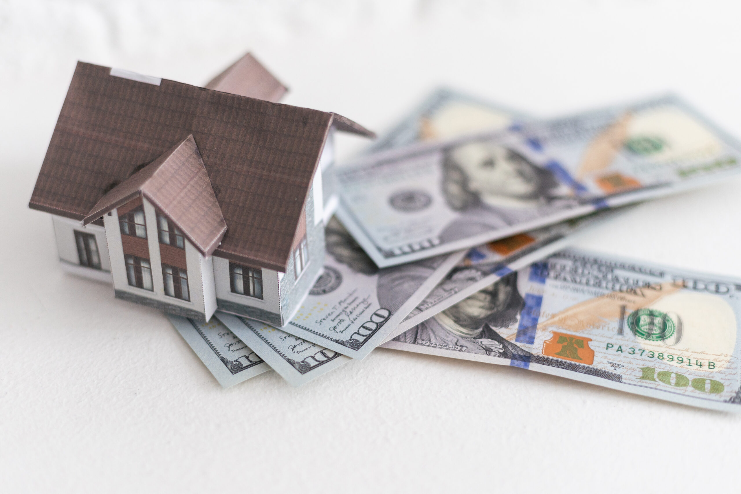 House standing on a pile of dollar bills. Investment, real estate and property concept Celestial Solar & Water Systems, Inc. house perched on green dollar bills with a brown roof and white walls, symbolizing Nevada solar rebates grants